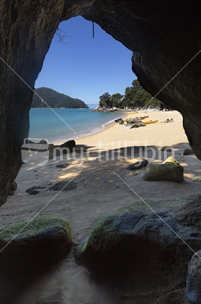 Sea cave frames golden sandy beach at Akersten Bay, Abel Tasman National Park