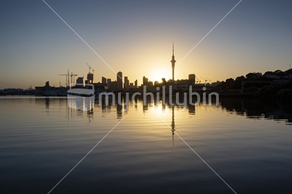 Sunrise over Sky Tower and Auckland city skyline viewed from Westhaven Marina (near focus)