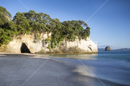 Waves gently lap the pristine beach at at Cathedral Cove, Coromandel