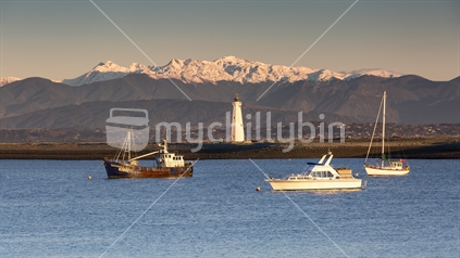 Mt Arthur in winter snow with Boulder Bank lighthouse, Nelson