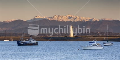 Mt Arthur cloaked in winter snow with Boulder Bank lighthouse, Nelson Haven