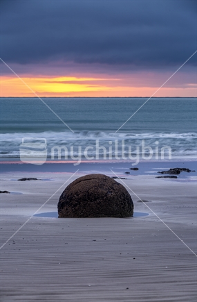 Single Moeraki boulder on Otago beach at sunrise