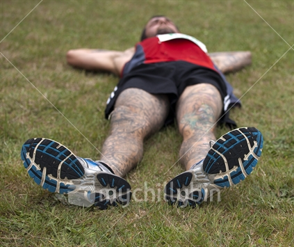 Tattooed runner resting after fast 10Km race