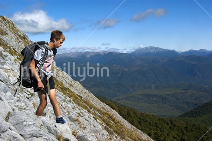Teenage boy tramper on scree slope of Mt Arthur Range. Kahurangi National Park. (raised ISO)