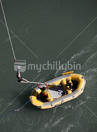 After!  Young woman bungee jumper gets collected by yellow raft.