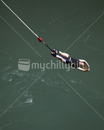 Young woman bungee jumps above the Kawerau River, near Queenstown