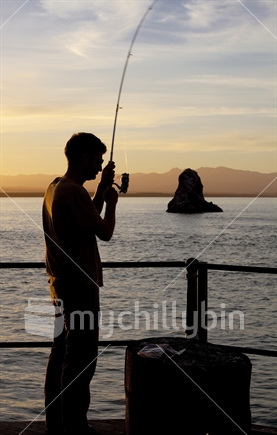 Fisherman silhouetted against Tasman Bay, Nelson