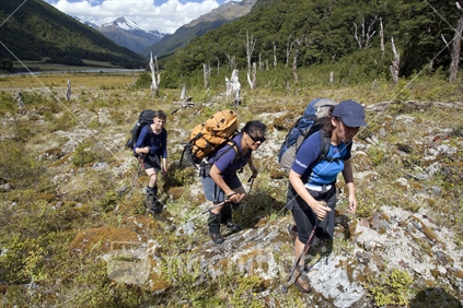 Three trampers walk river flats at Jumboland, deep in the heart of Mt Aspiring National Park