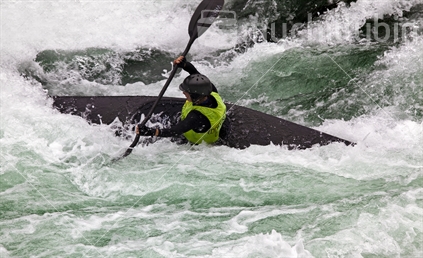 Female kayaker in sleek black boat, O'Sullivans Rapid, Buller River