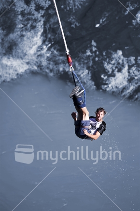 Blue Baptism - Guy bungee jumper with wet head above Kawerau River, on the rebound after a dunking, near Queenstown 