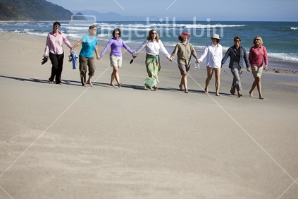 8 ladies walk deserted beach on Heaphy Track, Kahurangi National Park