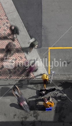 Busker welcomes a donation at Nelson's iconic Saturday markets - aerial view (motion blur)