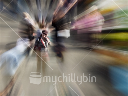 Zoom burst - Female shopper stops to answer mobile phone in crowded market