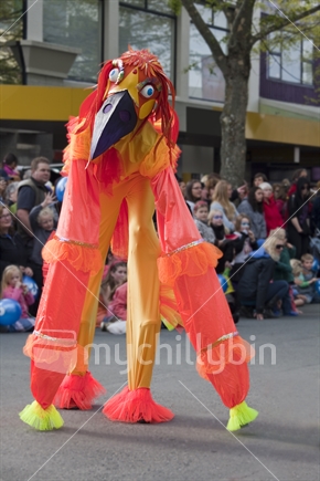 Brightly coloured stilt walking creature delights the crowd at Nelson's annual Masked Parade
