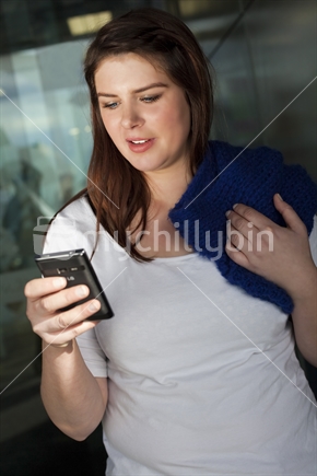 Young brunette girl texting on smart phone. Portrait orientation.