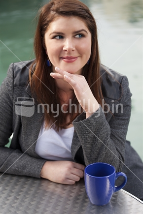 Young brunette girl in winter coat with coffee mug