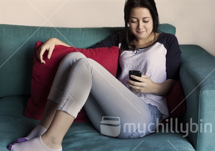 Teenage girl text messaging on her smart phone