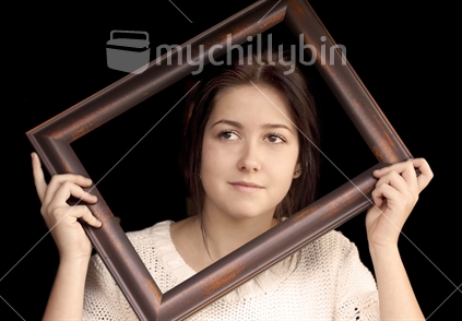 Teenage girl looks out from inside picture frame
