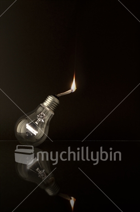 Explosion of ideas - an illuminated light bulb with lit fuse