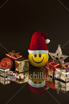 Happy Christmas - yellow smiley face ball wearing Santa hat
