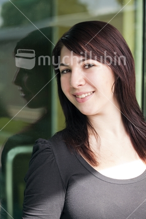 Brunette girl reflected in urban window with Lomo effect applied
