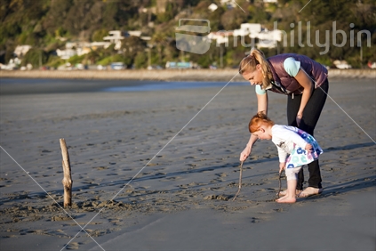 Young Kiwi mum with small girl on beach