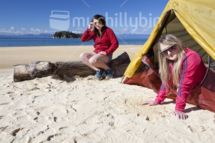 Two young women camp on DOC's Great Walk in Abel Tasman National Park.