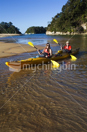 Couple land kayak on the idyllic waters of Kaiteriteri Beach.