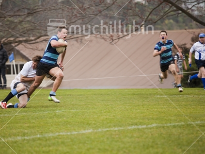 Nelson College rugby player breaks through tackle en route to the try line