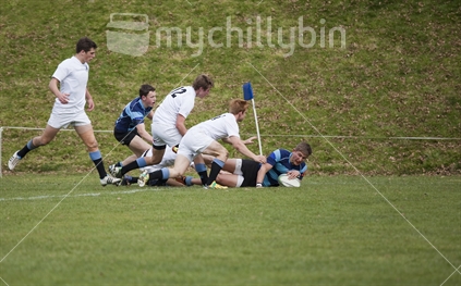 Five point landing. A college rugby player scores a try in the corner