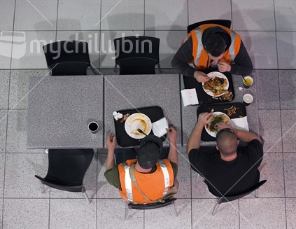 Working men eat lunch in public food hall. Aerial view.