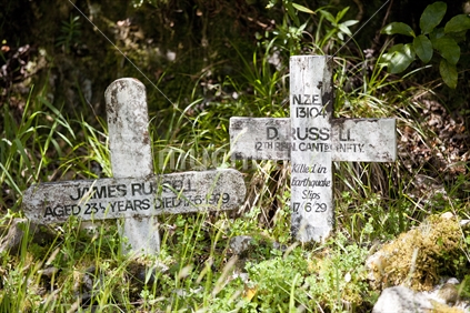 Twin crosses mark the place where miners perished at the start of the Old Ghost Road cycle trail, Mokihinui River, West Coast.  Right sign says D Russell died in a slip after an earthquake in 1929.
