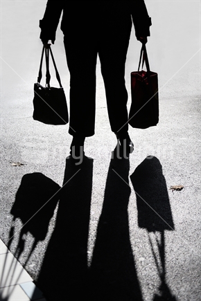Silhouette of lady shopper with long winter shadow across pavement