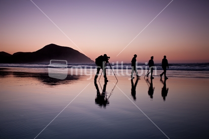 Photographer shoots friends on the remote Wharariki Beach at dusk