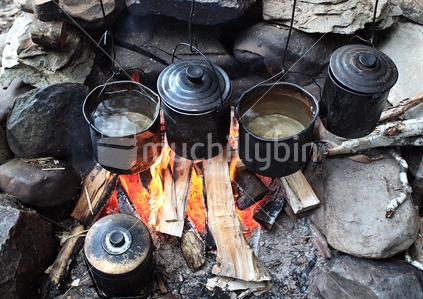 Five billies boil over rustic fireplace at Tent Camp, Cobb Valley, Kahurangi National Park