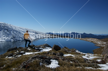Alpine tramper gazes out over Lake Sylvester, Kahurangi National Park