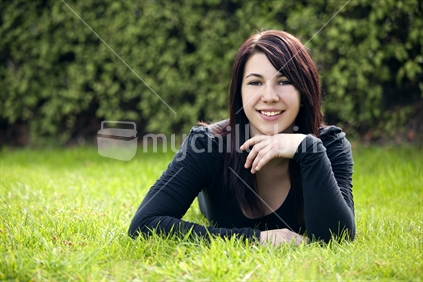 Gorgeous young woman lying on lush grass