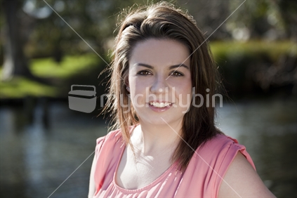 Beautiful girl smiles by the Avon River in Christchurch