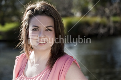 Beautiful girl smiles by the Avon River in Christchurch