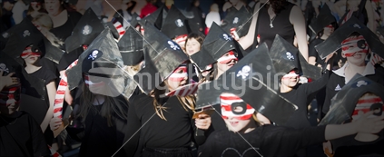Primary school children wear black pirate hats in Nelson's annual Masked Parade. 