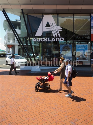 Auckland i-Site visitor centre on Quay Street with tourists and pram