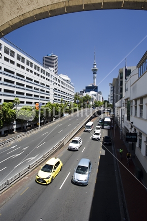Busy traffic on  Hobson Street with Auckland's iconic Sky Tower beyond