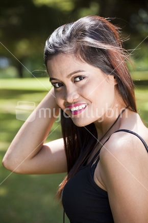 Smiley Asian girl poses in city park