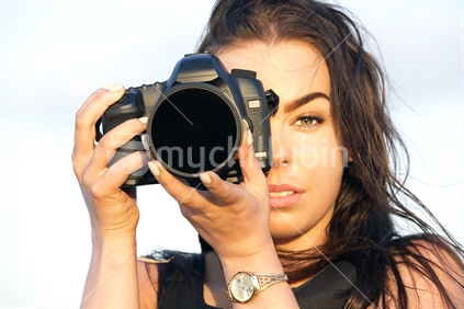 Attractive teenage girl holds DSLR camera