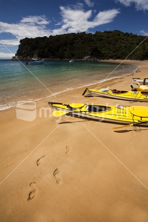 Footprints and yellow kayaks are symbols of summer in the Abel Tasman National Park