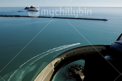Taking off over Port Taranaki in a helicopter looking out to the Sugar Loaves and the breakwater, and down to the beacon;  
