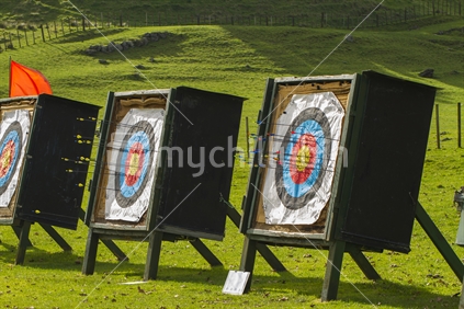 Archery butts with arrows and red danger flag