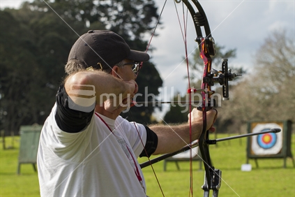 Archer taking aim at target that is in the background