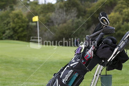 Golf trundler in foreground with out of focus pin flag behind