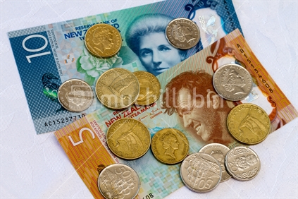 New $10 and $5 notes with some loose coins.  Note: Approved educational and commercial screen and print uses of NZ banknote images are detailed at: http://www.rbnz.govt.nz/notes_and_coins/issuing_or_reproducing/